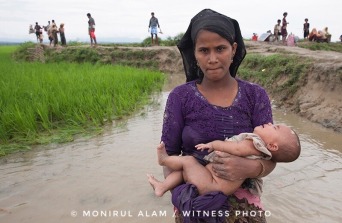 September 08, 2017 Takenuf, Bangladesh - Rohingya people, fled from ongoing military operations in Myanmar’s Rakhine state, make their way through muddy water after crossing the Bangladesh-Myanmar border in Teknuf, Bangladesh on September 2017.